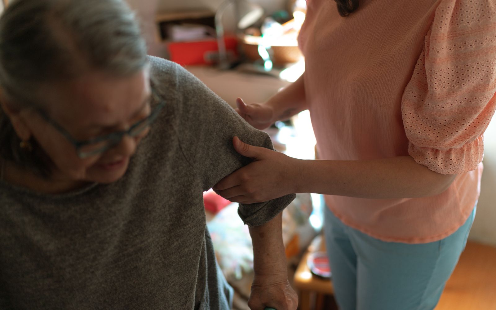 Caregiver assisting an elderly woman at home